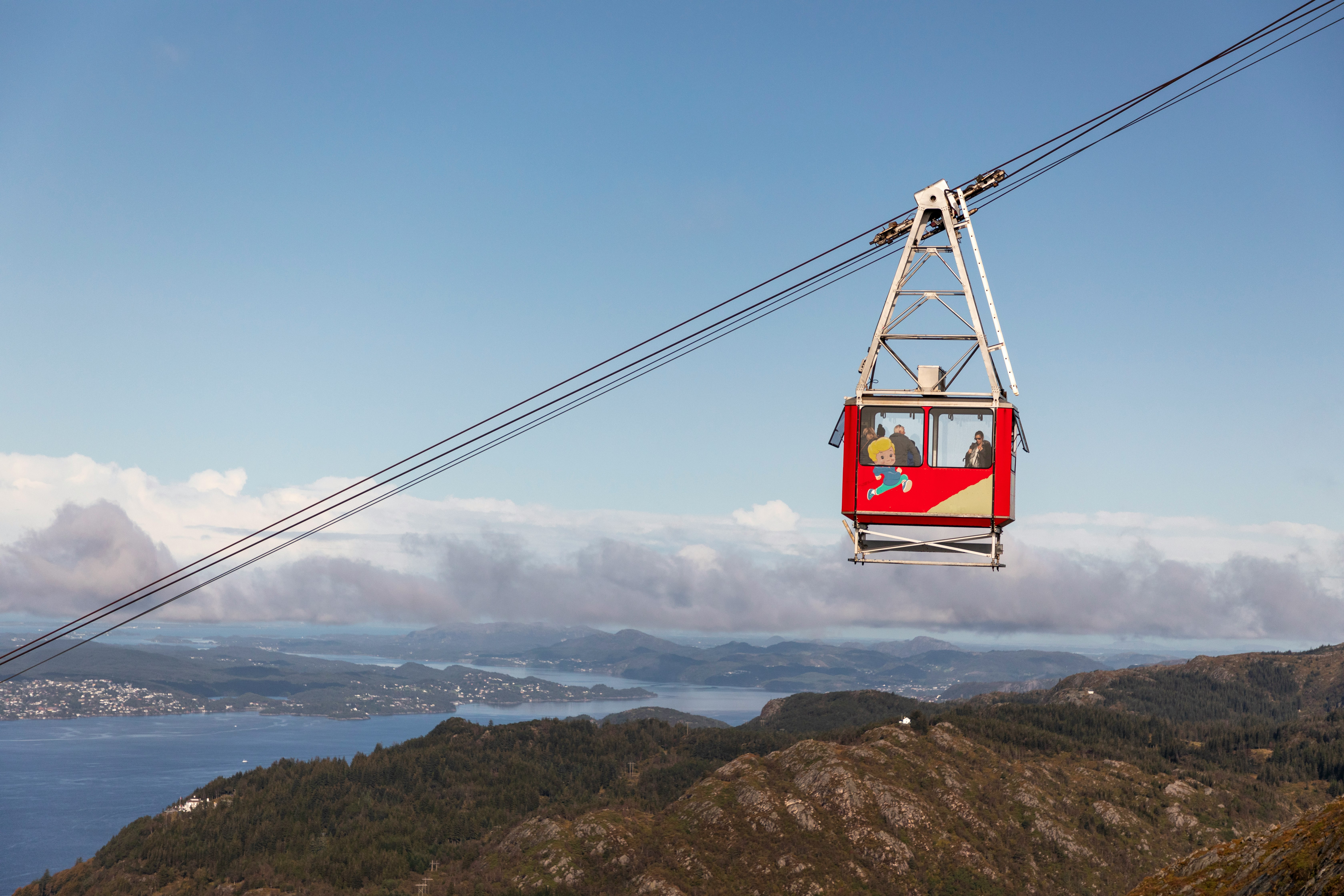 red cable car over the mountains during daytime